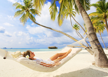 Picture of a young woman relaxing in a hammock on the beach, as an example of how relaxing sedation dentistry can be from Glendale, CA dentist Dr. Thein.